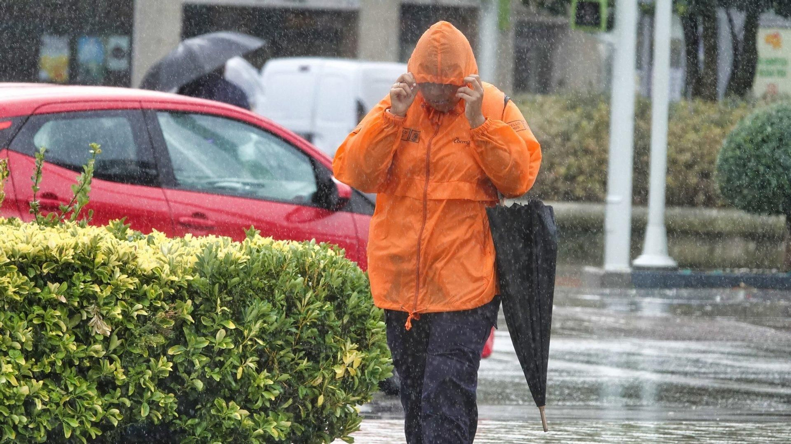 Una persona se protege de la lluvia en Vigo.