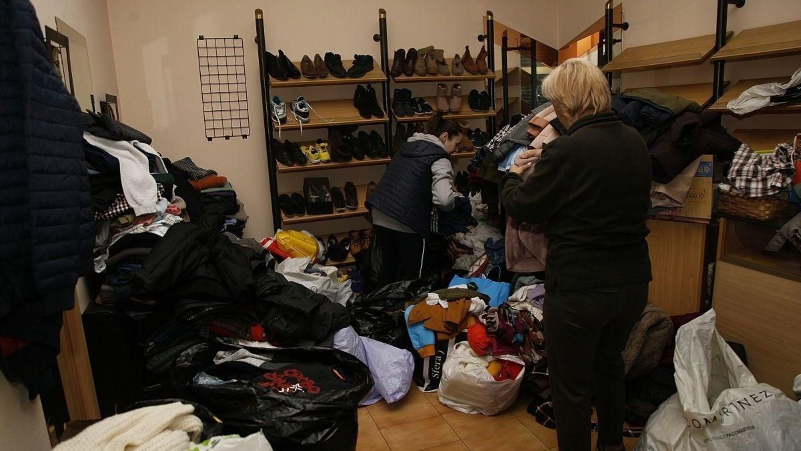 Las voluntarias Olga y Cristina organizan la ropa donada.