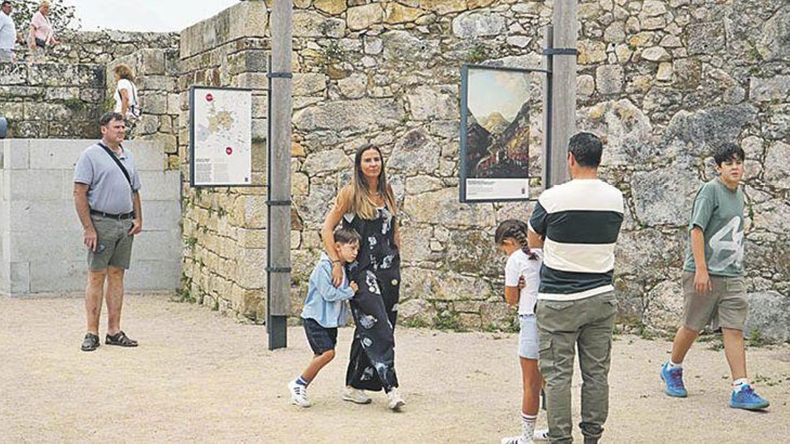 Arriba, el patio de armas de la fortaleza del siglo XVII con paneles divulgativos.