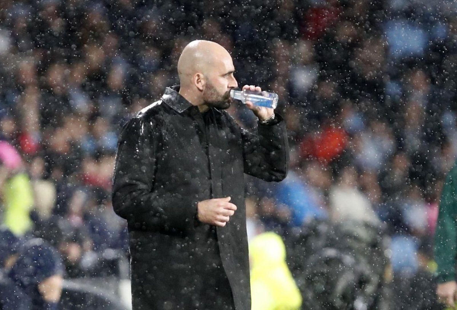 Claudio Giráldez bebe agua bajo la lluvia, ayer, en Balaídos.