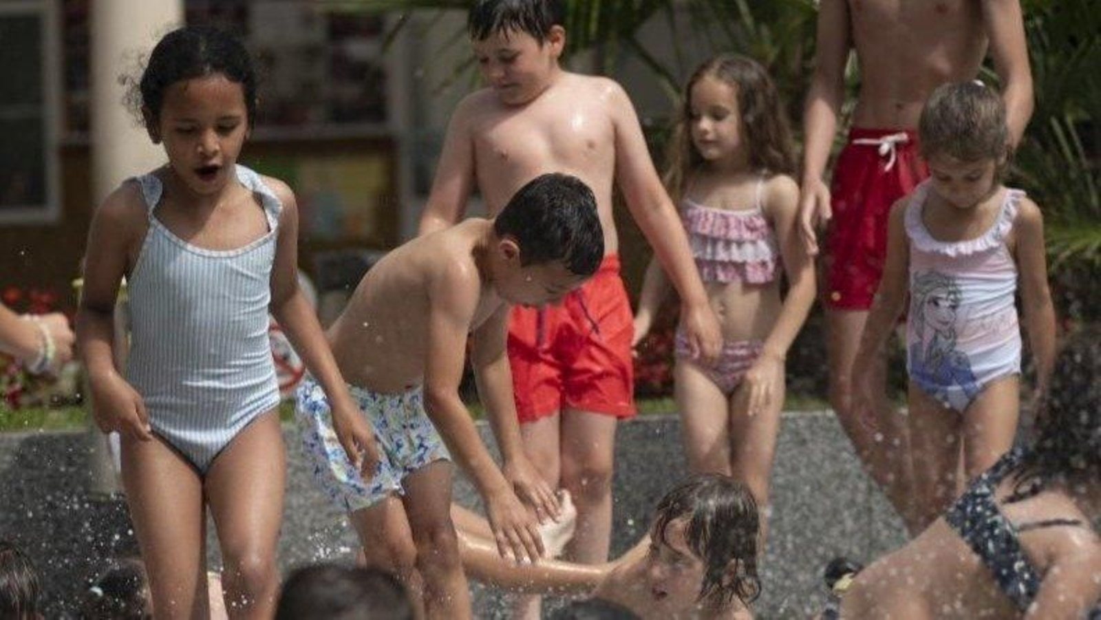 Los niños se refrescan durante la yincana en el patio del colegio salesiano. (Foto: Xesús Fariñas)
