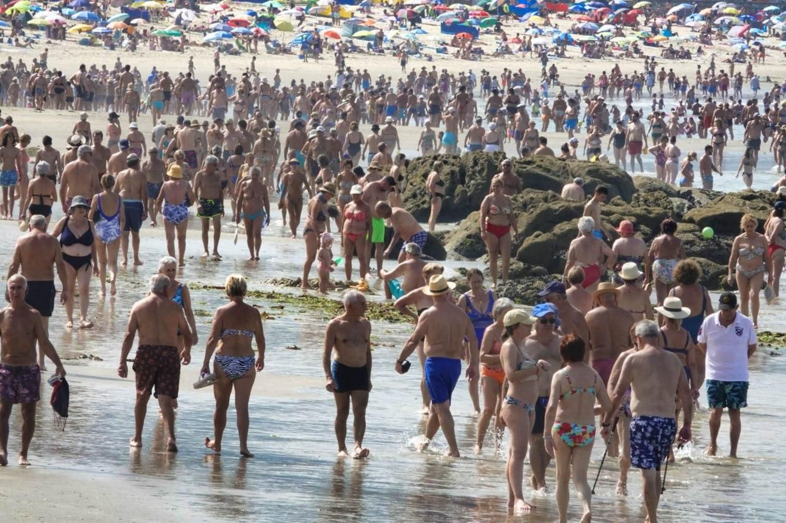 No había espacio ni en la orilla en la playa de Samil ante las miles de personas que acudieron. A la derecha, marcando 38 grados y la terraza vacía.