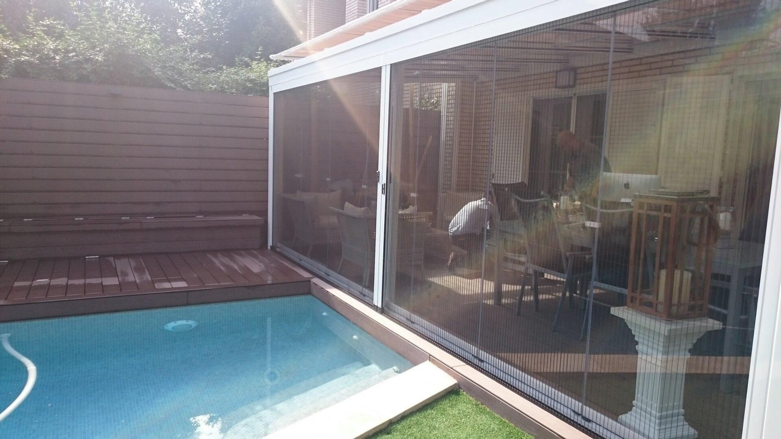 Mosquitera Iron50 instalada junto a una piscina.