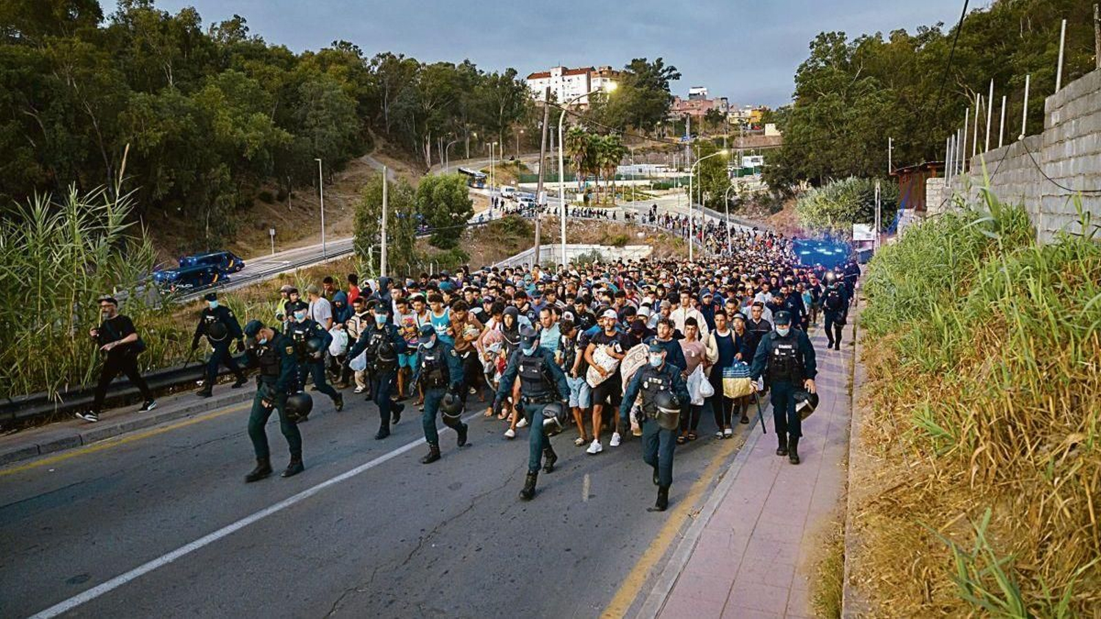 Varios agentes dirigen y protegen el traslado a pie durante el dispositivo de reubicación.