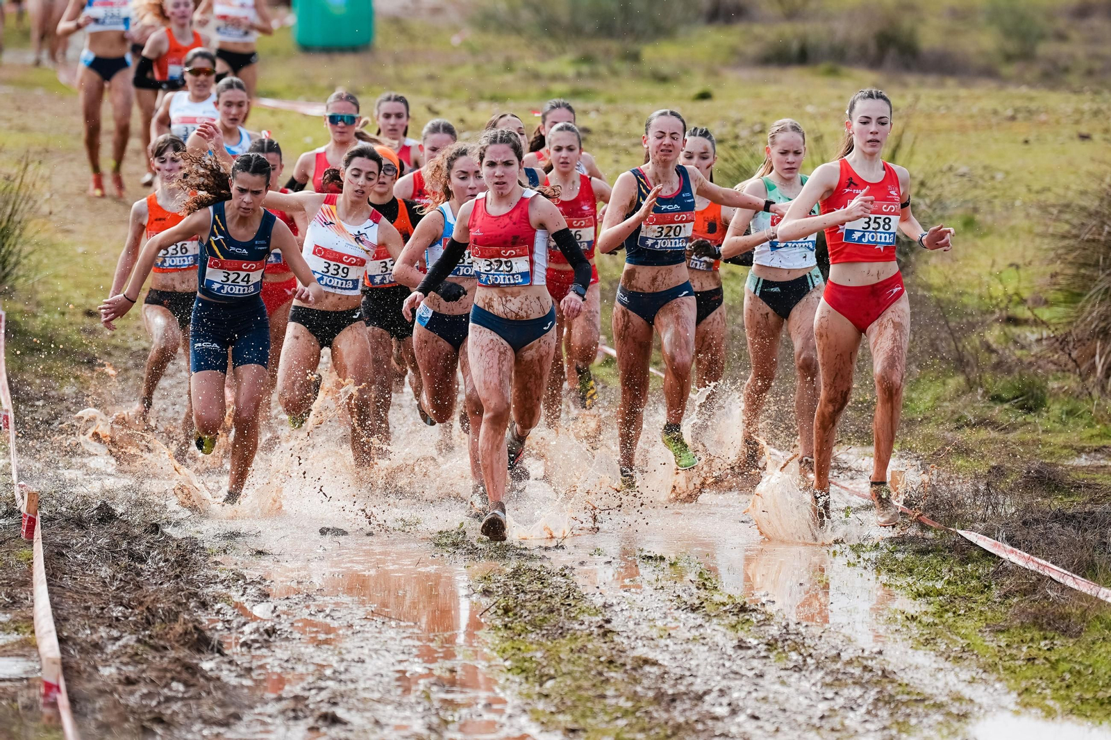 Las atletas pasan un charco en el que costaba mantener el equilibrio.