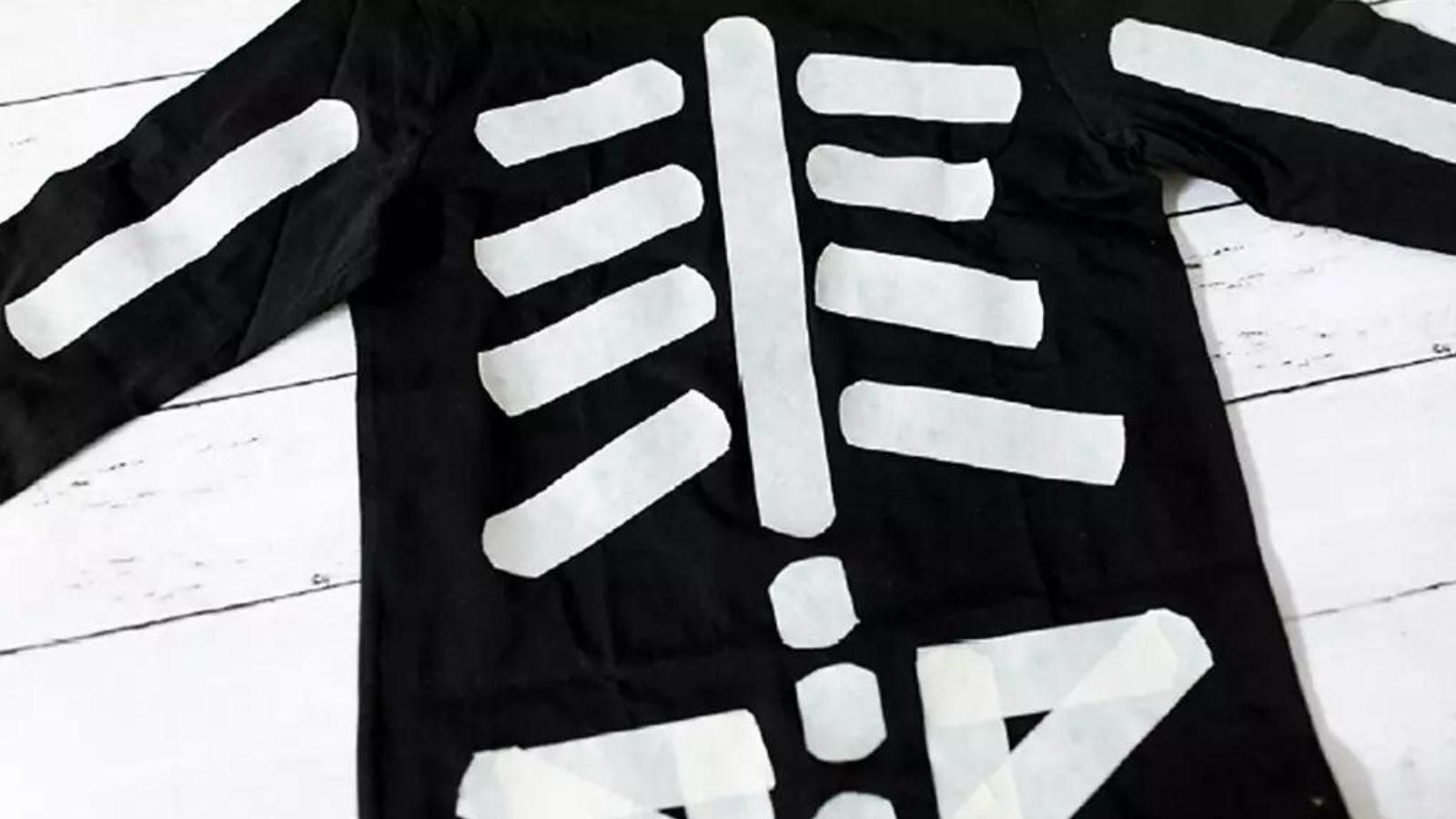 Camiseta y pantalón negros con tiras blancas que dibujan los huesos. Una opción económica y fácil de preparar en casa.