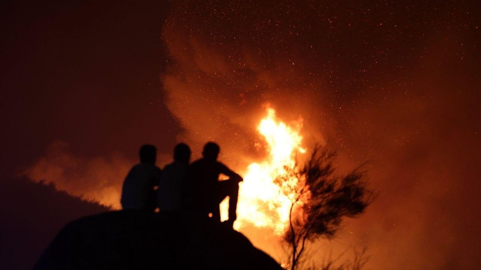 Un grupo de personas observa cómo el fuego devora la vegetación en Vila Verde.
