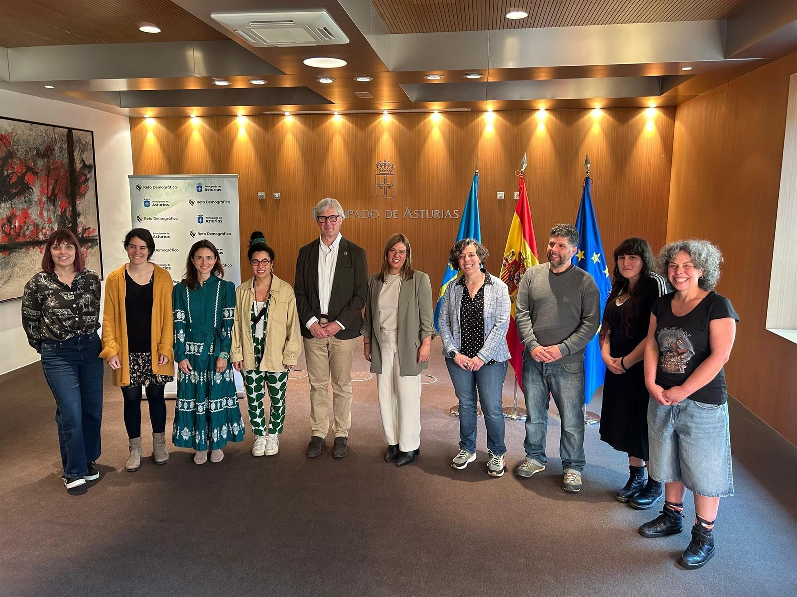 El director general de Reto Demográfico, Marcos Niño, y la vicepresidenta del Principado, Gimena Llamedo, junto a personas asentadas en Asturias en la reunión que han celebrado este miércoles en Oviedo.