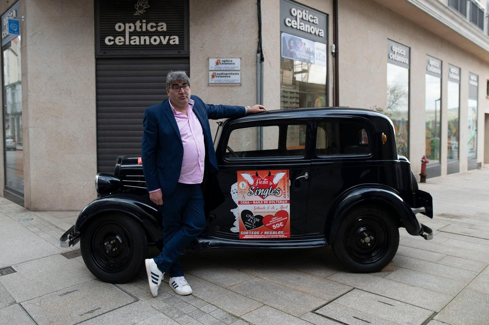 Organizador principal de la fiesta posando con el coche que hace patrocinio de la misma.
