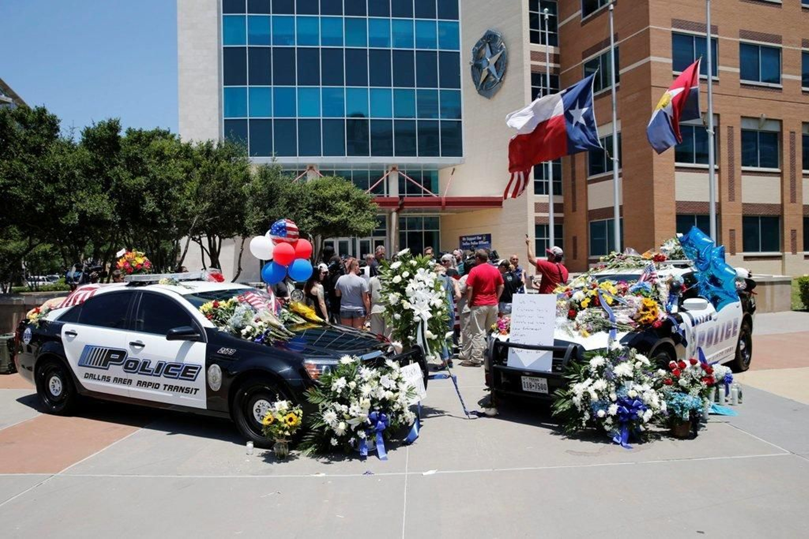 Los ciudadanos colocaron flores y mensajes en los coches patrulla fernte a la Comisaría de Policía de Dallas.