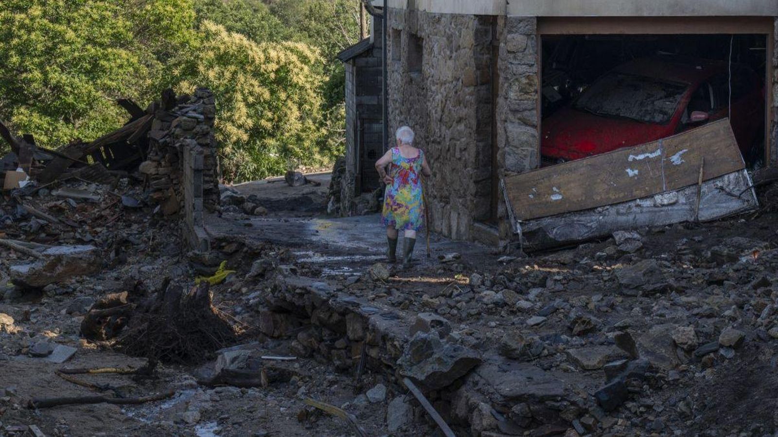 Una vecina camina entre los destrozos del pueblo de A Bouza (Viana), epicentro de la riada que sacudió el oriente ourensano el pasado miércoles.