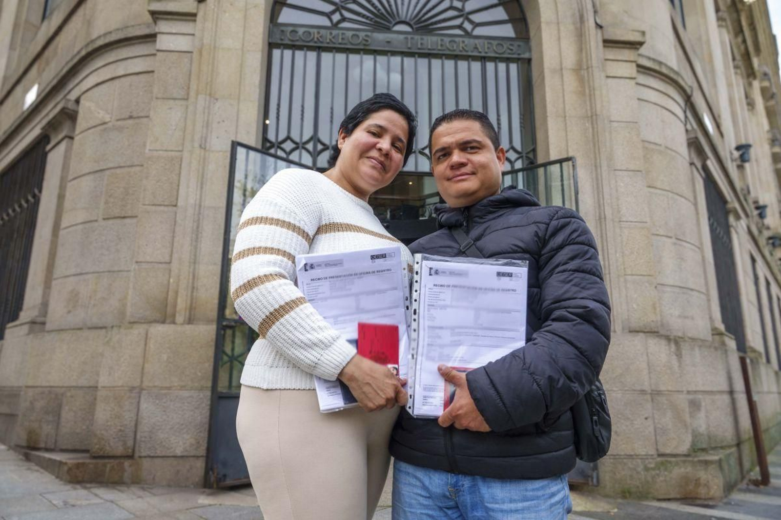 Yuliana y Carlos posan ayer delante de la oficina de Correos de Vigo tras realizar los trámites para la regularización