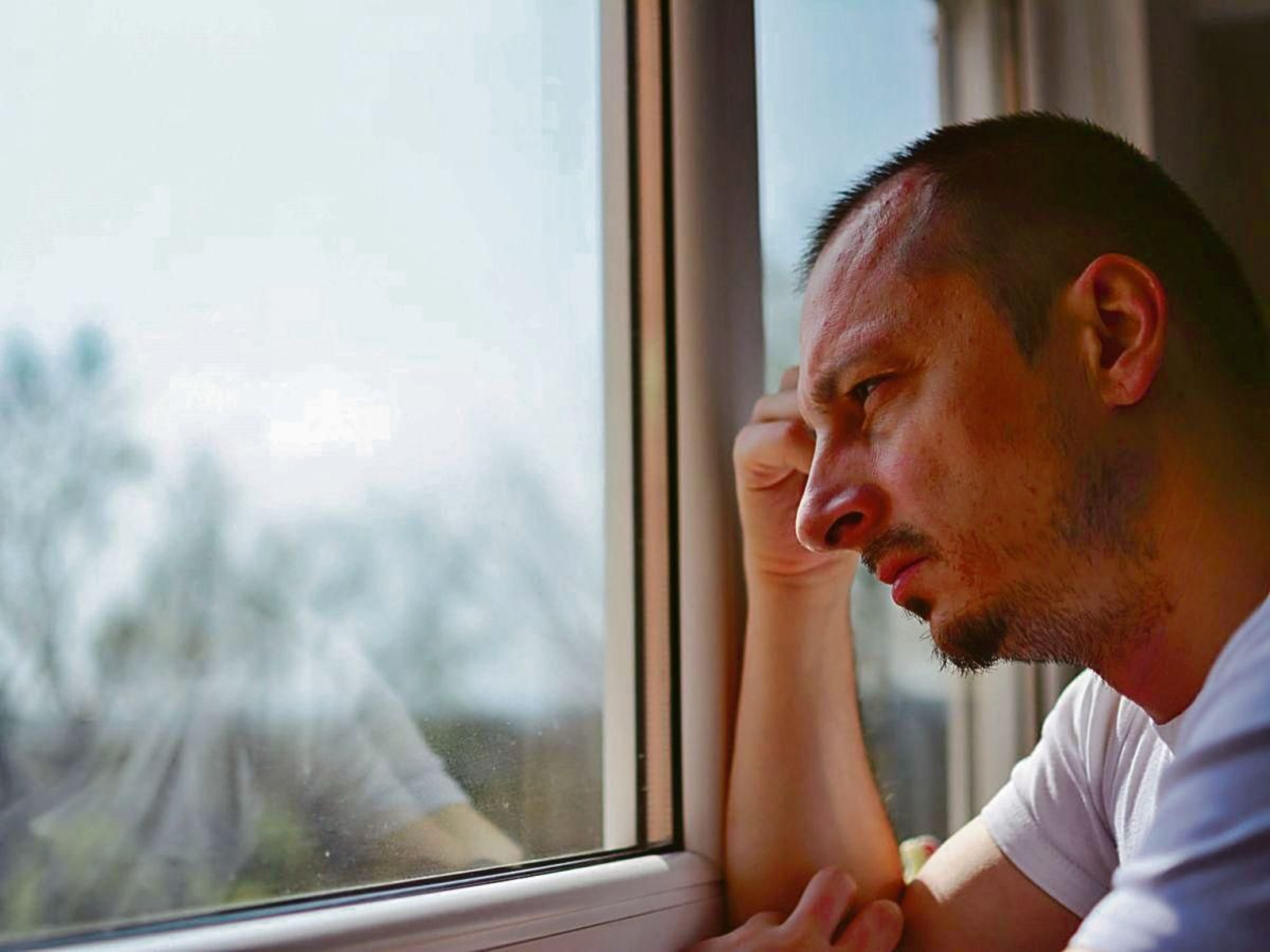 Un hombre mira a través de la ventana.