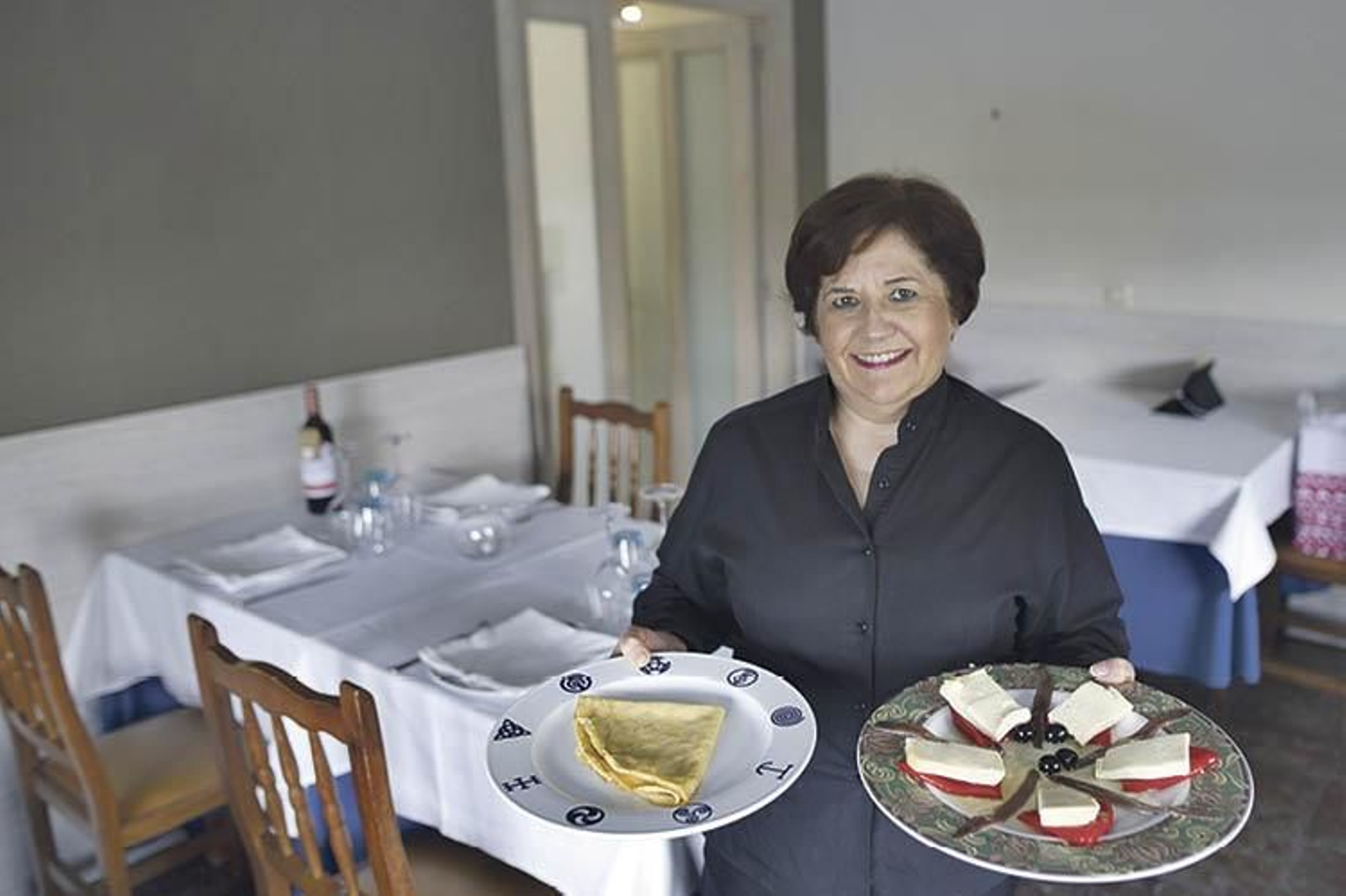 Mari Nieves con dos de los platos estrella de O Colmear, filloas y queso con piquillo y anchoas. (Martiño Pinal)