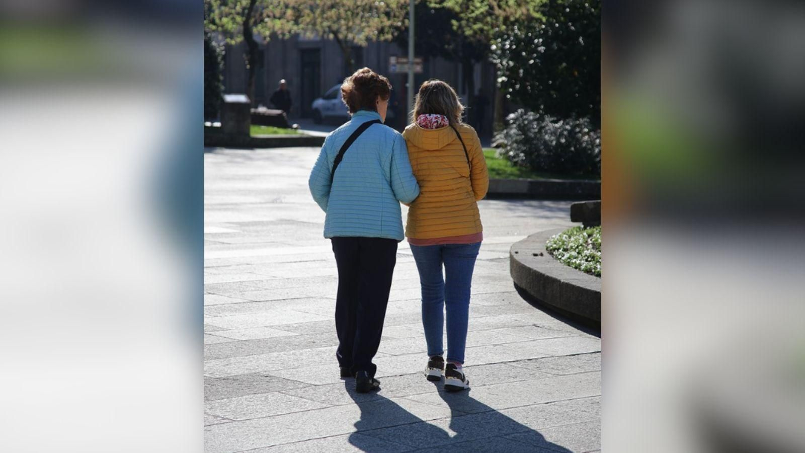 Dos personas mayores caminan por Ourense.