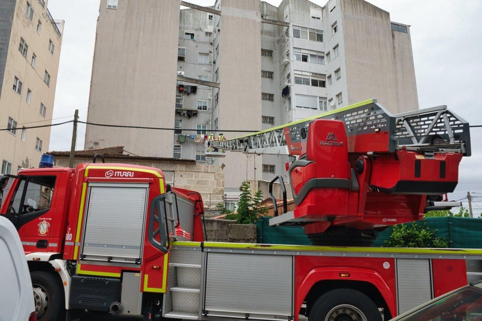 Bomberos con la grúa comprueban el estado de la estructura de la vivienda.