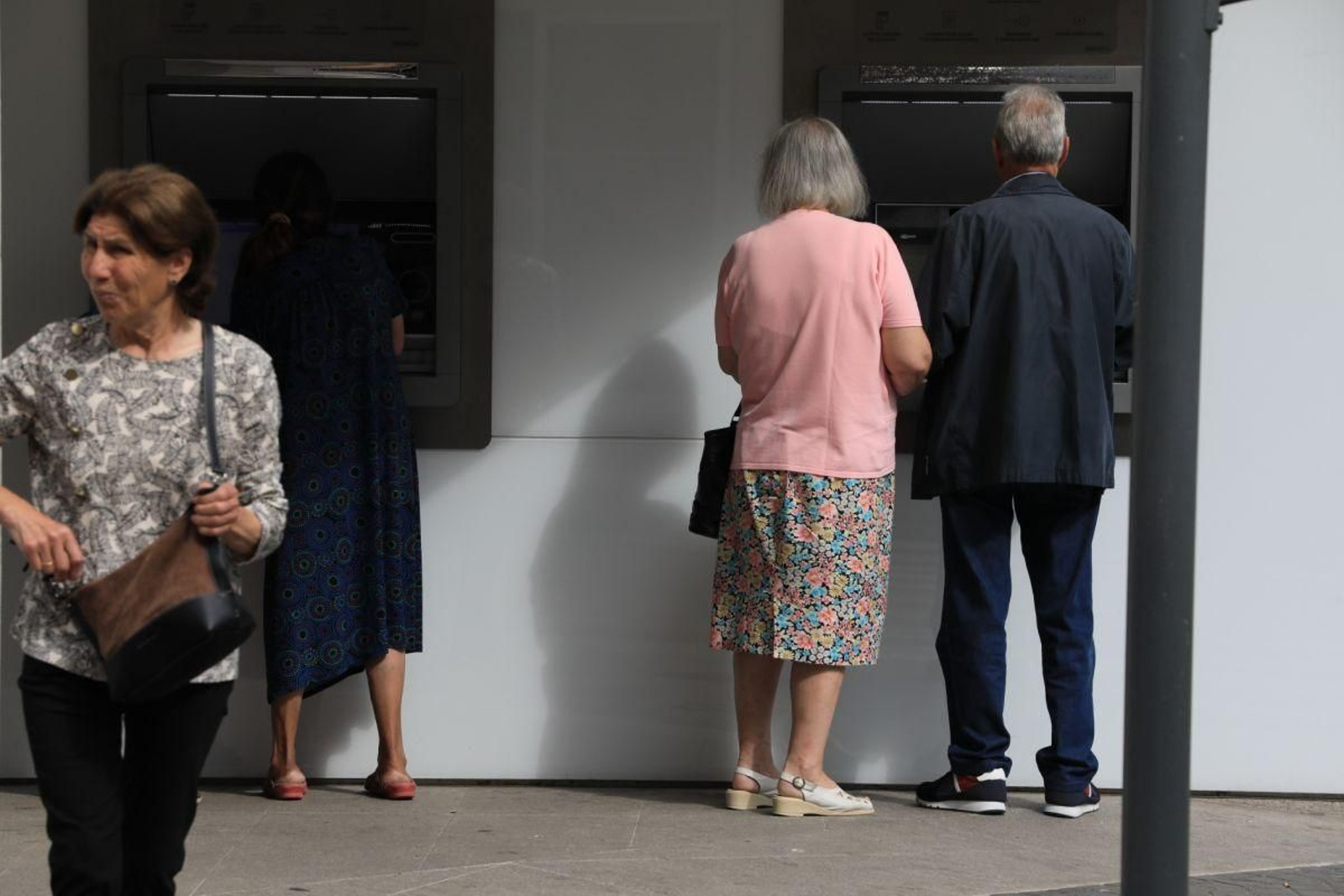 Dos personas en un cajero de la ciudad.