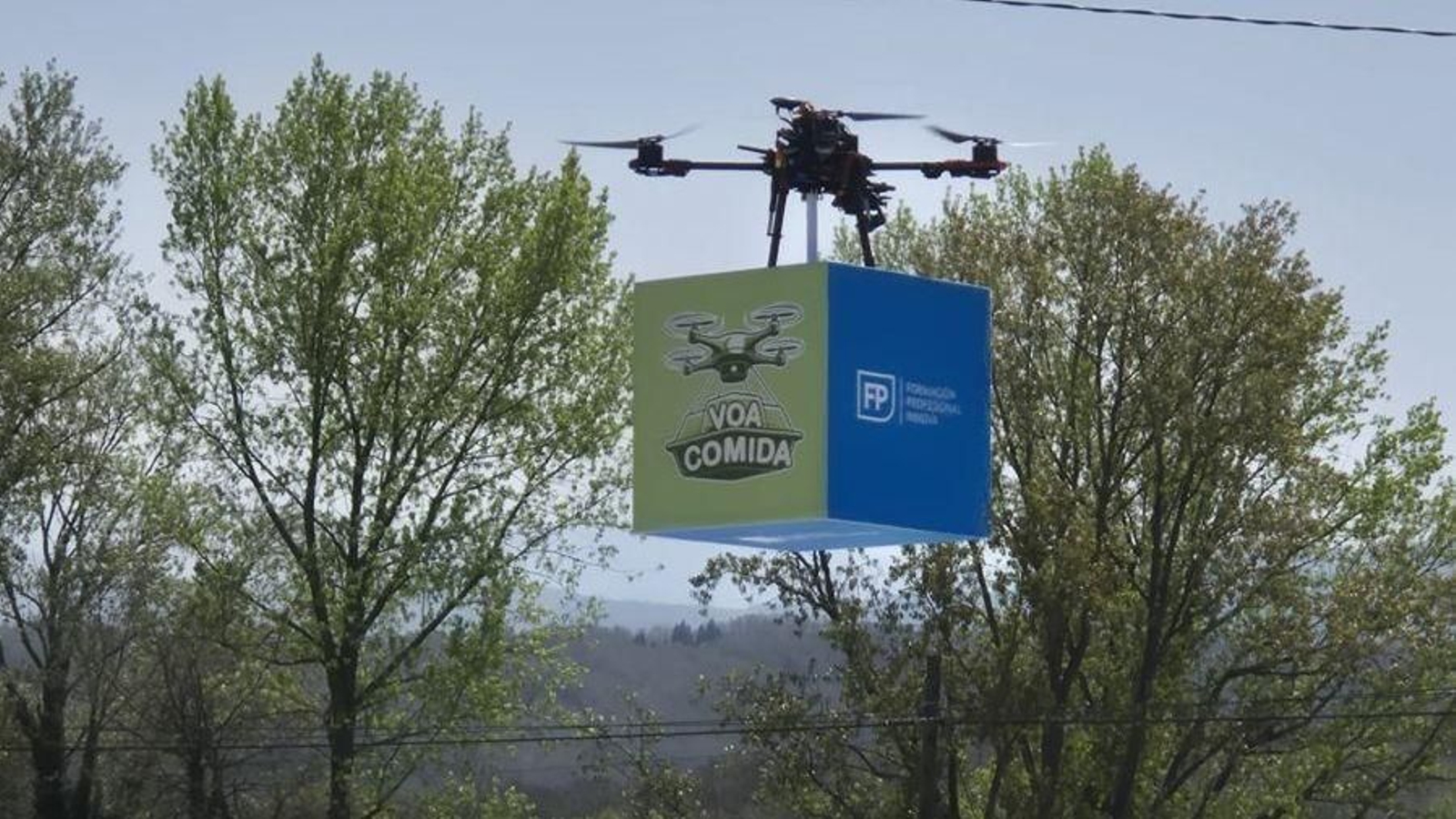 Dron sobrevolando en San Xoán de Río con su caja de comida.