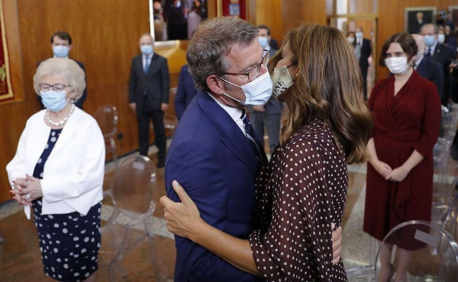 Feijóo recibe la felicitación de su pareja, Eva Cárdenas, en presencia de su madre y de Ayuso tras tomar posesión de su cargo ayer en el Parlamento.