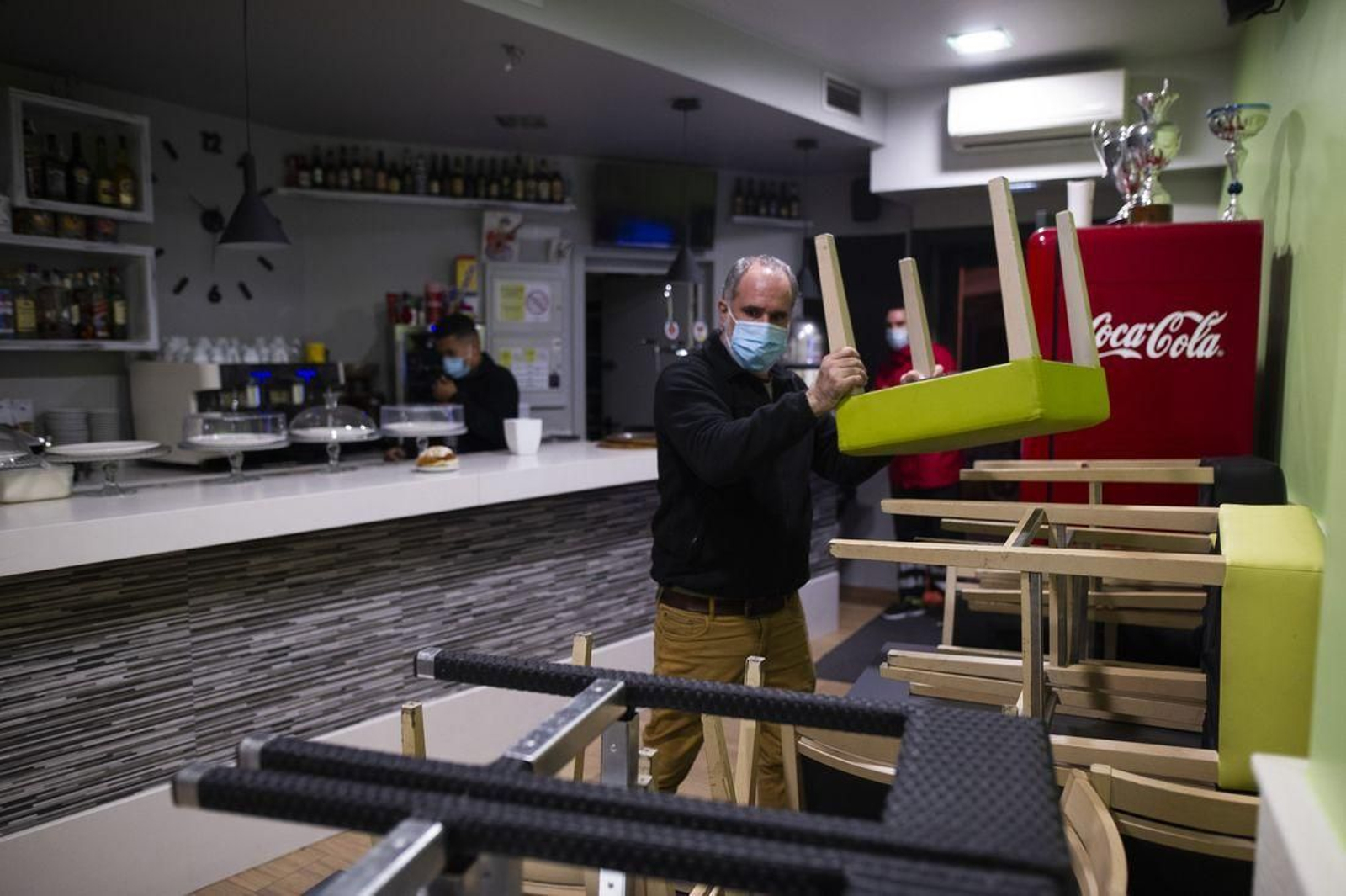 Un hostelero recoge el bar después de que los últimos clientes se hayan marchado, ayer por la noche. (Foto: Martiño Pinal)