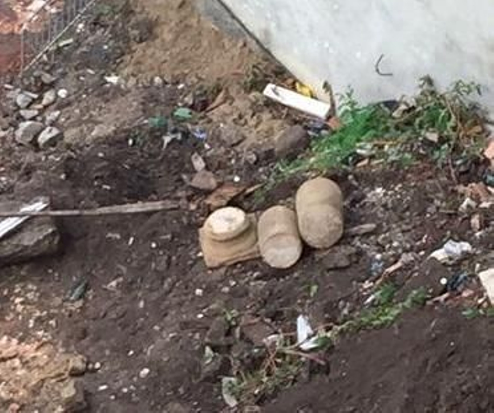 Imagen de la basa y dos fragmentos de columna, sobre los escombros.