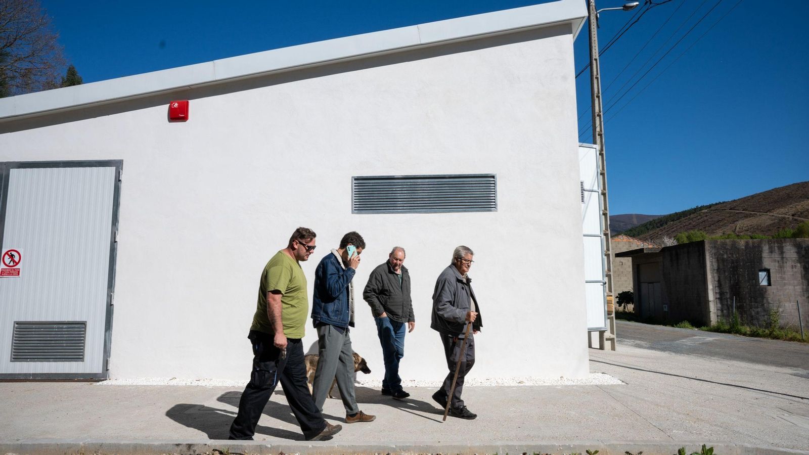 Los vecinos caminan junto a la nueva caldera comunitaria.