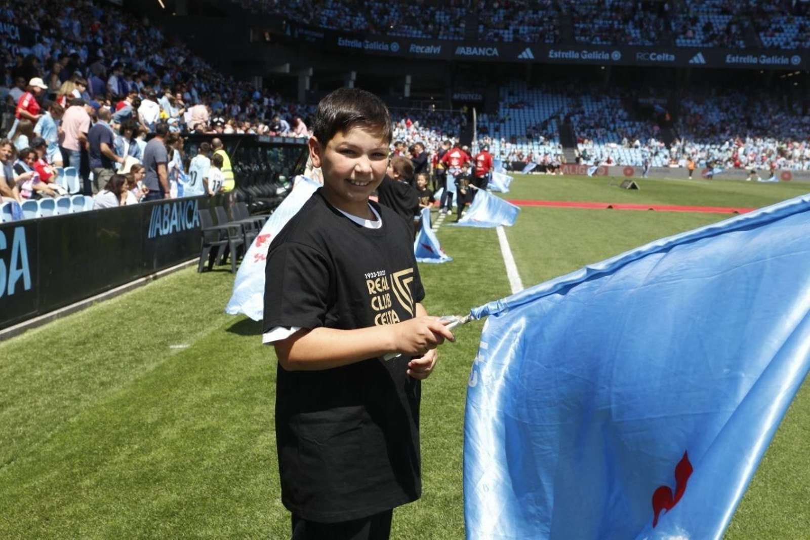Un niño con la bandera en el campo.