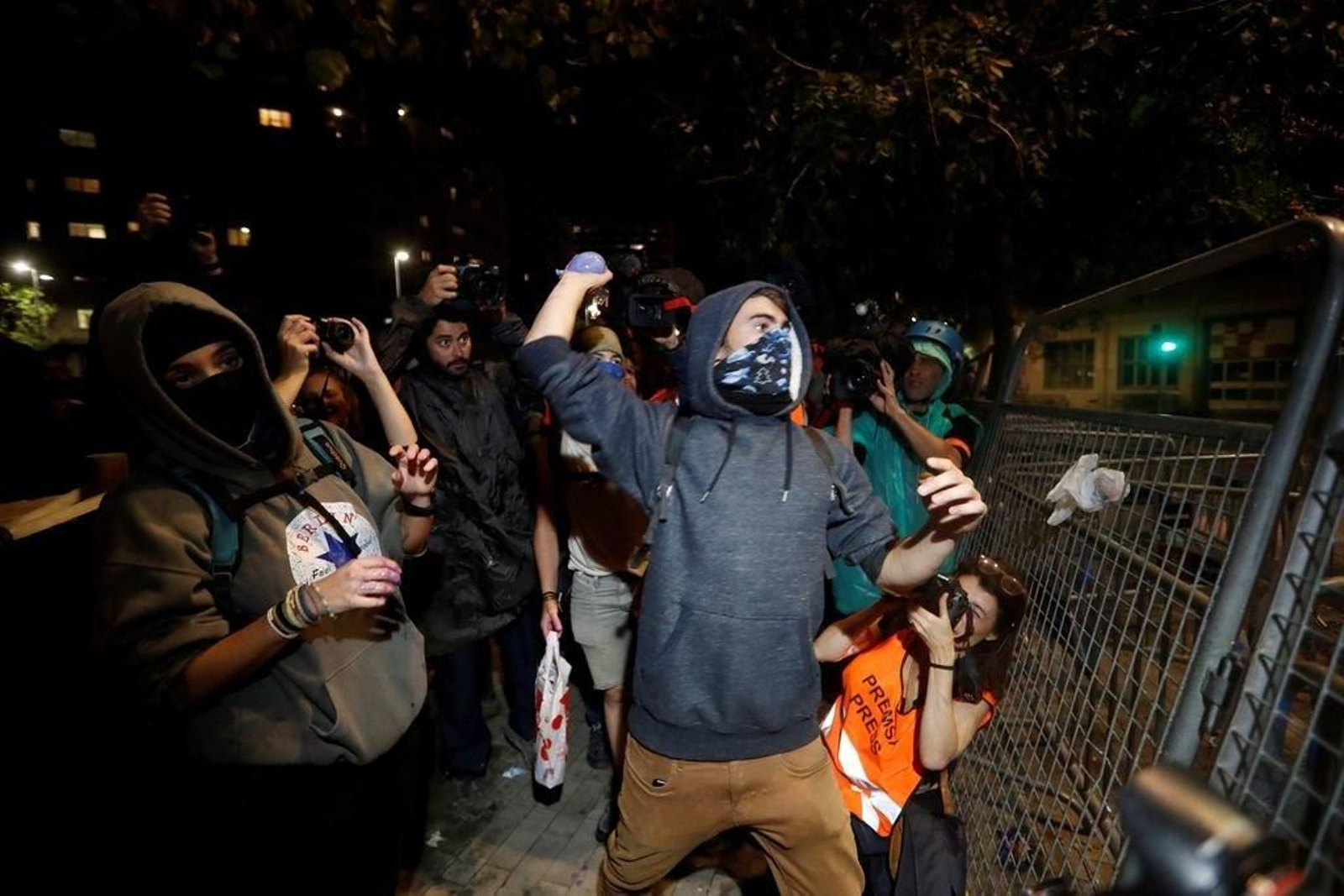 Un radical lanza un globo de pintura contra una furgoneta antidisturbios.