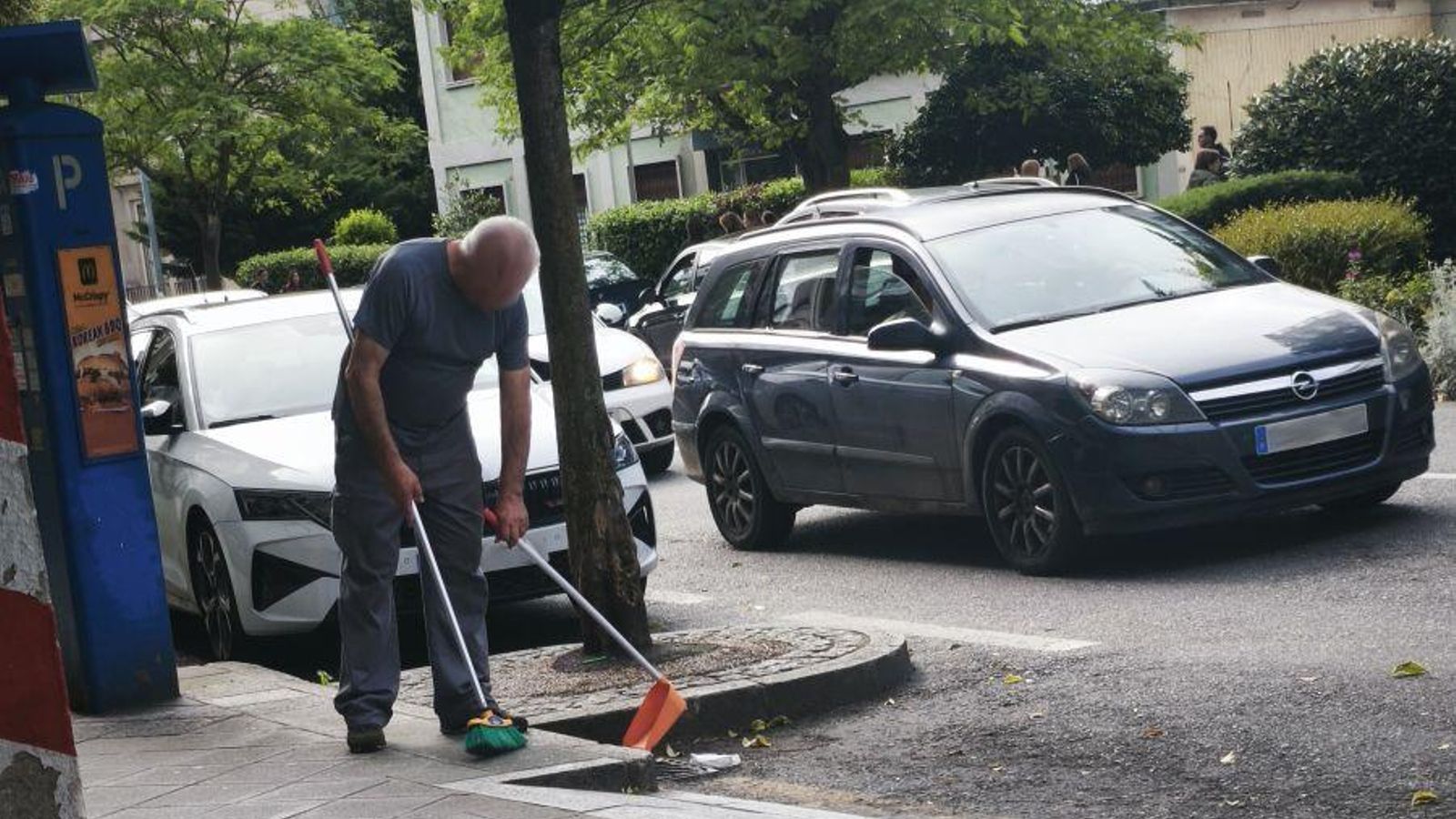 Hombre recoge basura de un sumidor.