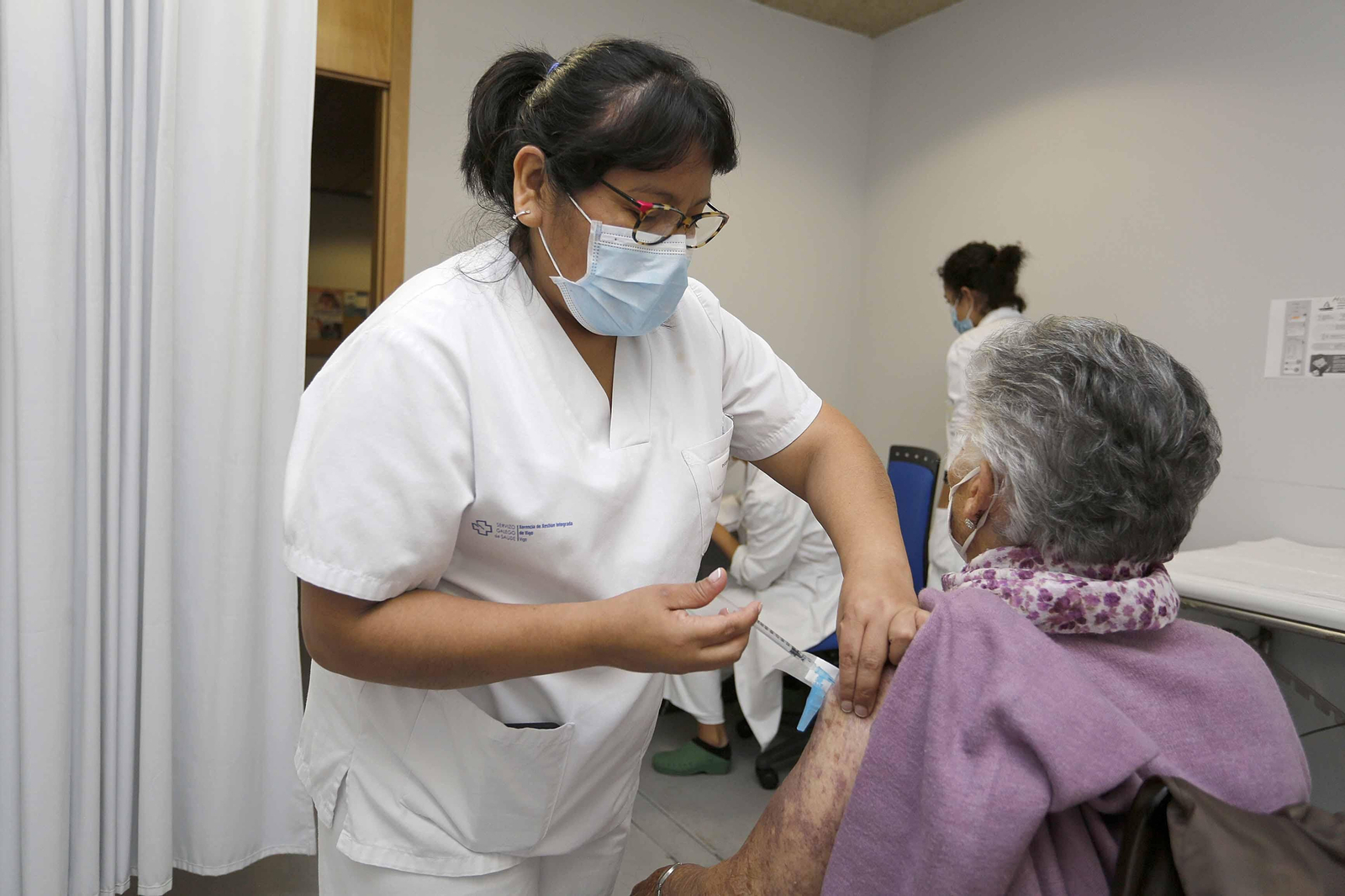 Una enfermera vacuna a una persona mayor en un centro de salud de Vigo.