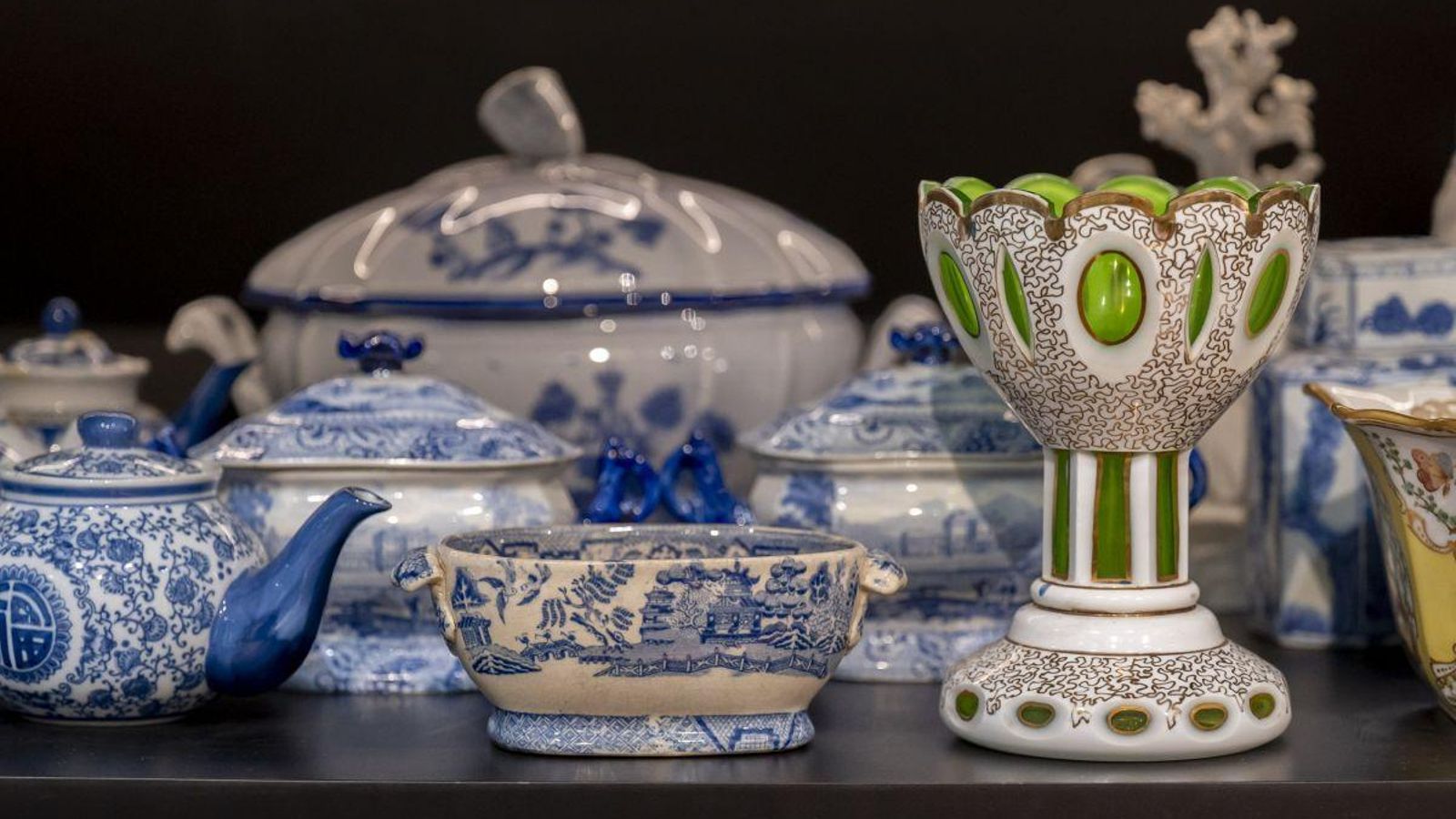Varios piezas de porcelana descansan en una repisa.