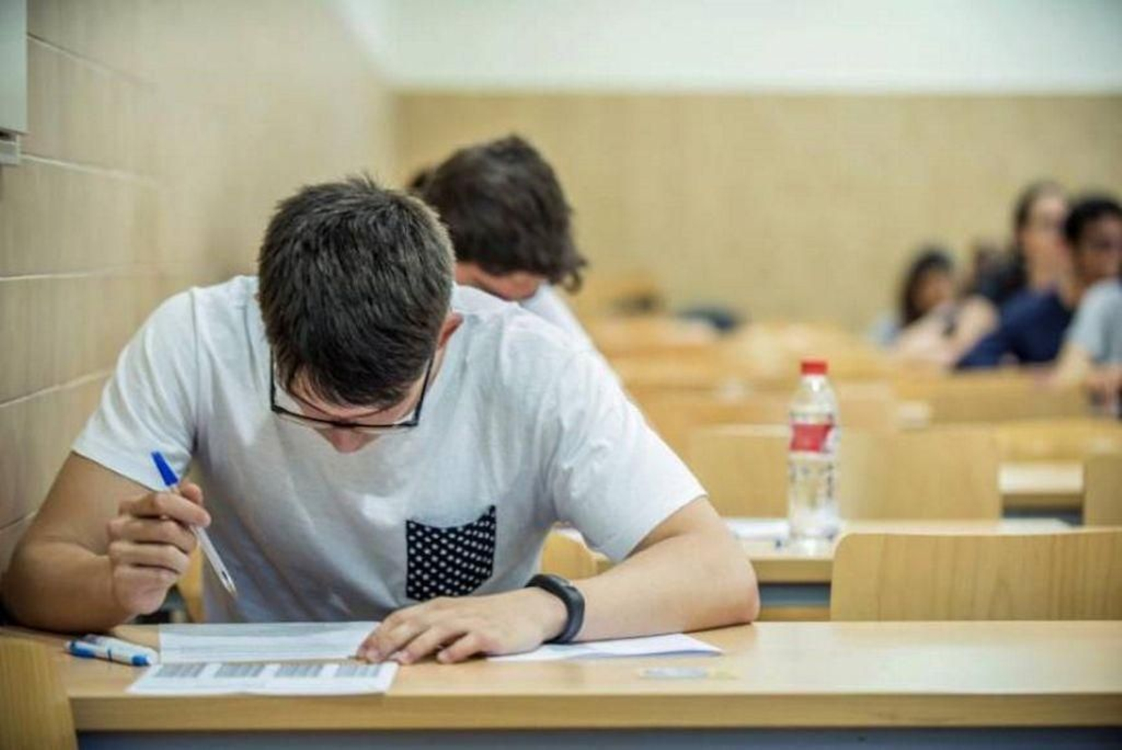 Un grupo de personas realiza un examen en un aula.