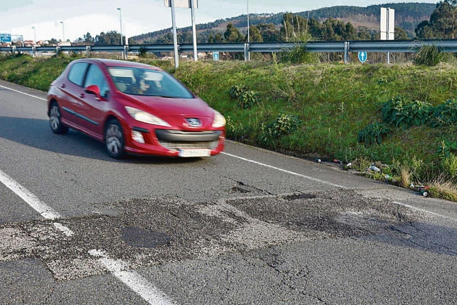 Baches en la salida de la VG-20 en dirección al hospital Cunqueiro, un problema para las ambulancias.
