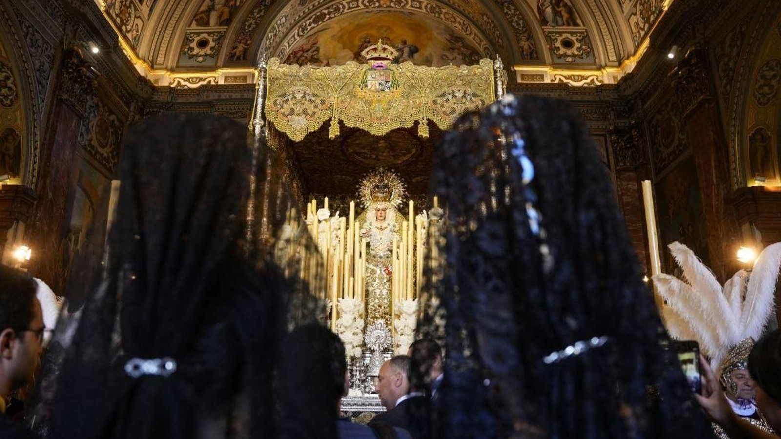 Mujeres ataviadas ante la virgen en el Jueves Santo de Sevilla.
