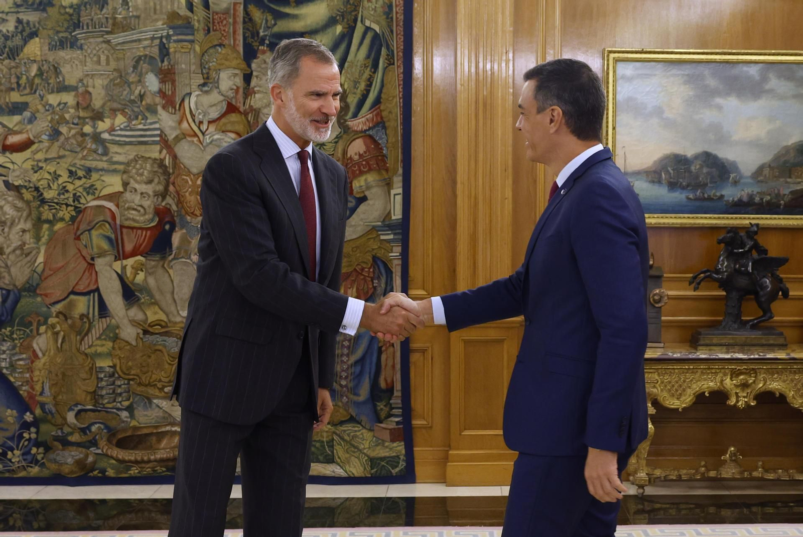 El rey Felipe VI (i) estrecha la mano al líder del PSOE y presidente del Gobierno en funciones, Pedro Sánchez. // EFE