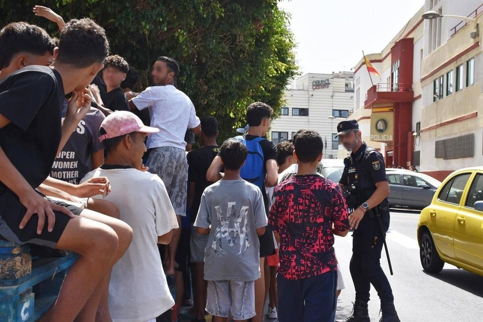 Un grupo de menores espera para ser filiado en una comisaría de la Policía Nacional en Ceuta.
