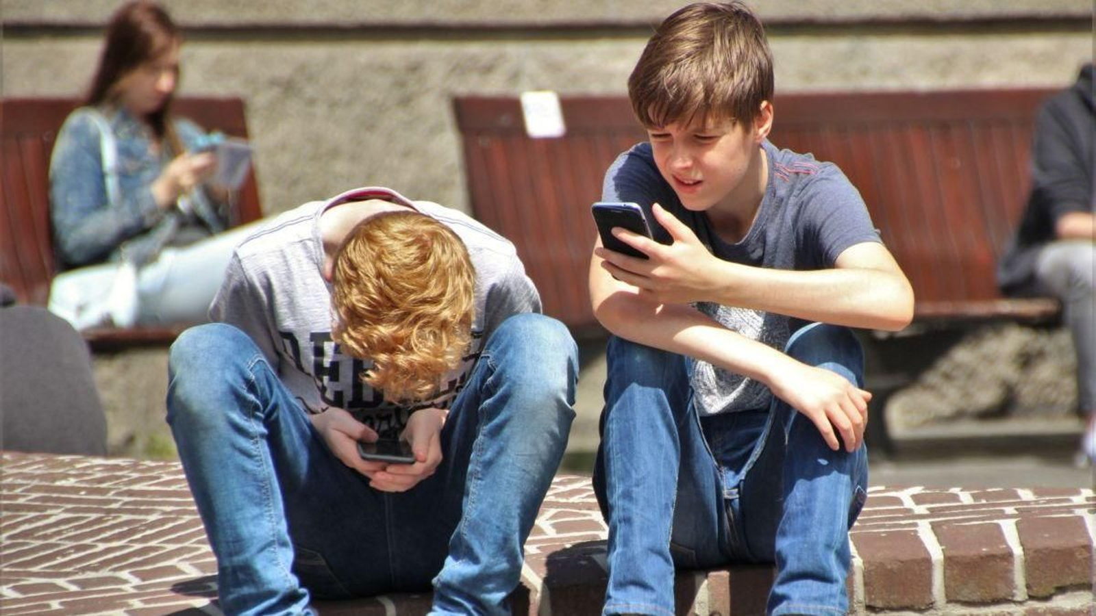 Dos adolescentes conectados a internet desde sus móviles.