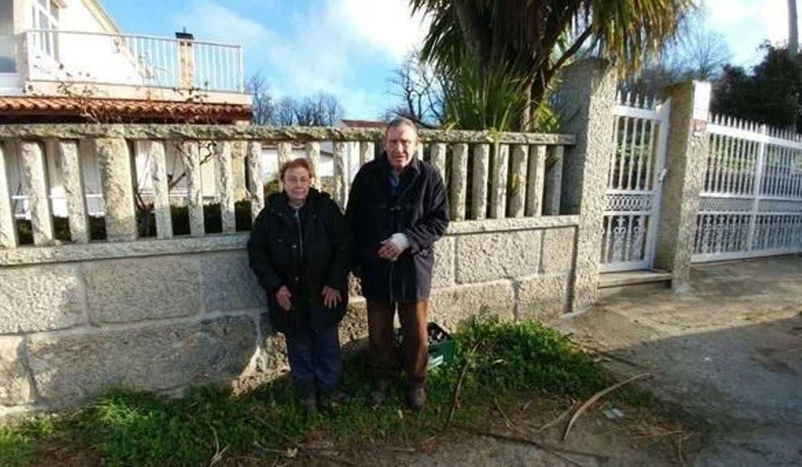 Adoración Vibe y Ramón Rodríguez, en la entrada de su casa en la que fueron agredidos por cinco encapuchados, en San Mamede de Urrós.