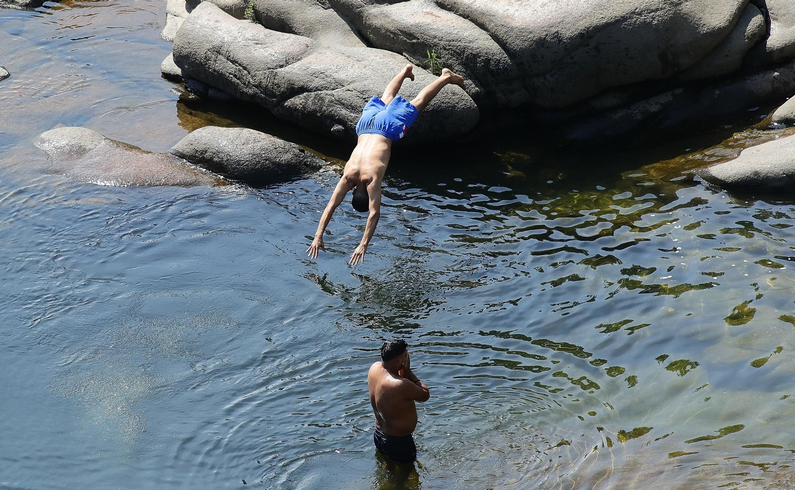 Un ourensano se refugia de las altas temperaturas en el Miño.