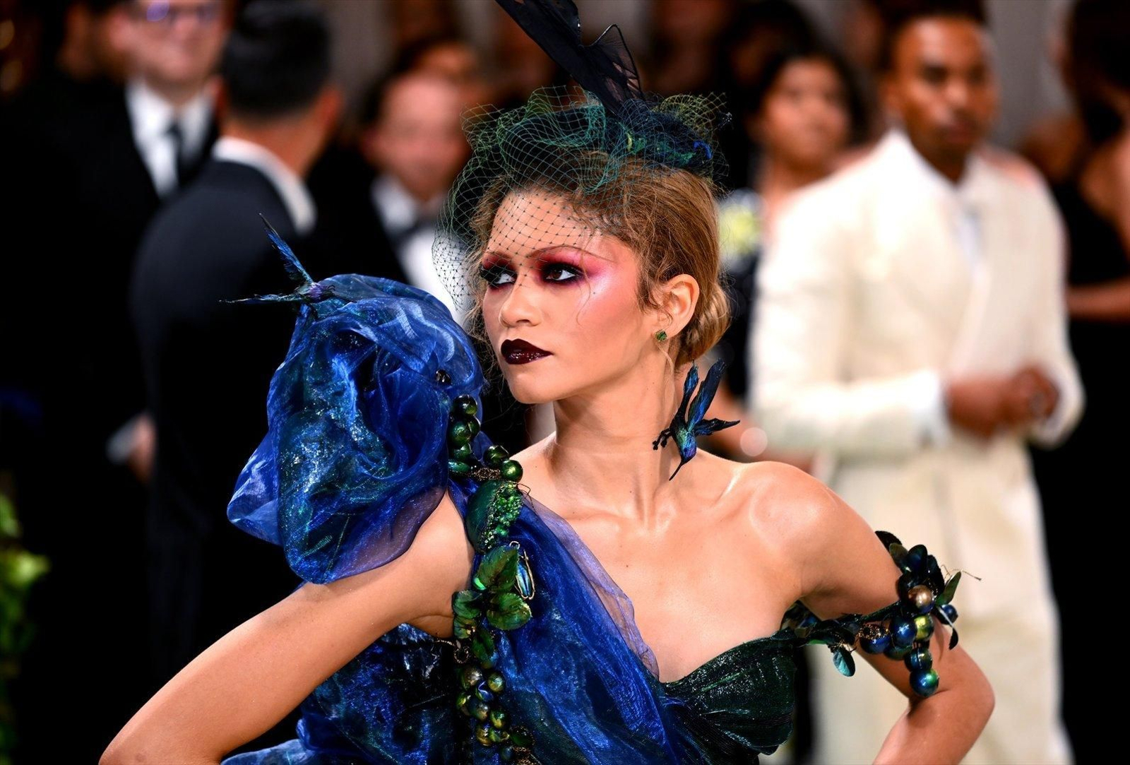 Zendaya. Otra de las madrinas de esta edición tampoco ha defraudado. La actriz ha desfilado por la escalinata del Met con dos diseños; el primero, una ensoñación surrealista de Maison Margiela X John Galliano confeccionado en organza negra y azul eléctrico a franjas con bustier verde, una voluminosa flor en el hombro y corte sirena. Su excesivo maquillaje, la guinda a un nuevo acierto de la protagonista de `Euphoria` en la gran cita de la moda.