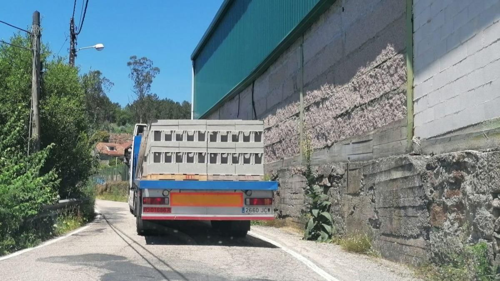 Los camiones de gran tonelaje deben maniobrar en una carretera de doble sentido, con viviendas cercanas, con curvas cerradas y un peraltado muy peligroso para estos vehículos.