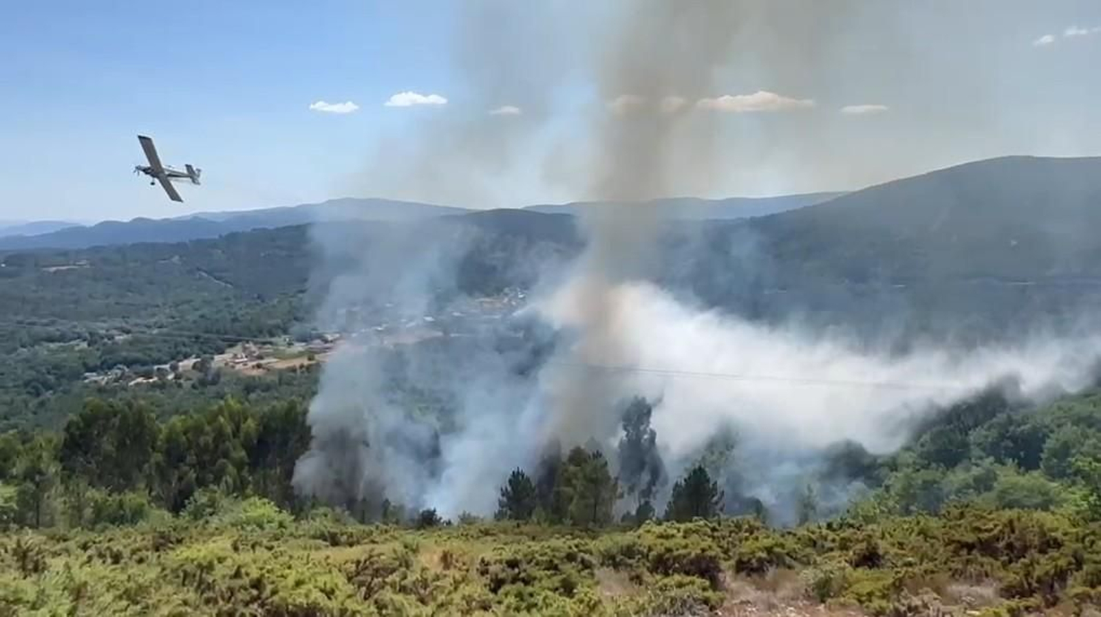 Un avión de extinción descarga agua sobre el incendio forestal declarado en la parroquia de Xurenzás, en Boborás.