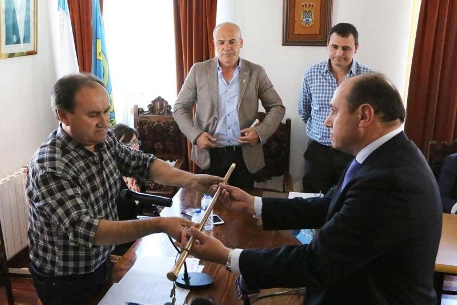 Horacio Gil recibiendo el bastón de mando ante la mirada del alcalde saliente, Xabier Simón.