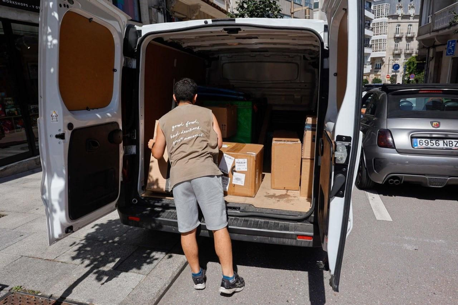 Un repartidor recoge los paquetes de su furgoneta para entregar.