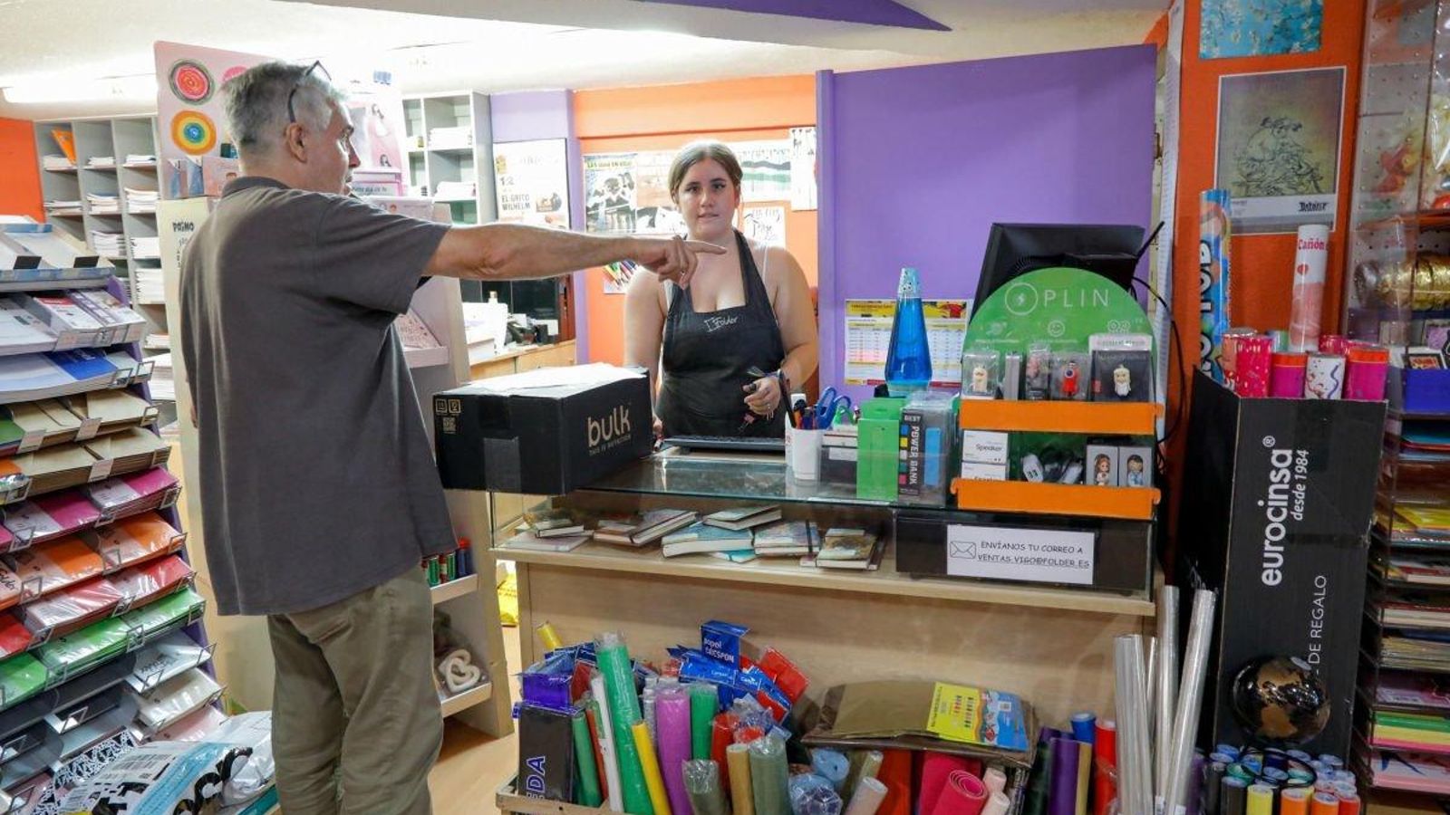 Jorge, de la papelería Folder, atiende a una clienta en busca de material escolar.