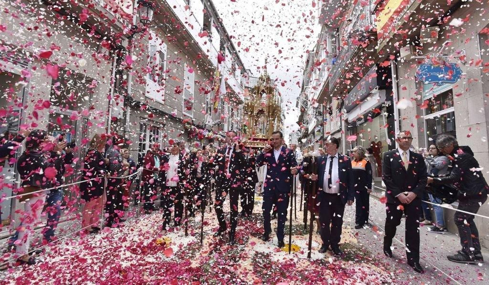 El paso del Santísimo fue recibida desde los balcones bajo los que pasaba con el lanzamiento de mieles de pétalos rosas que cubrieron durante unos minutos las calles de Ponteareas en uno de los momentos más vibrantes y emotivos de la procesión de