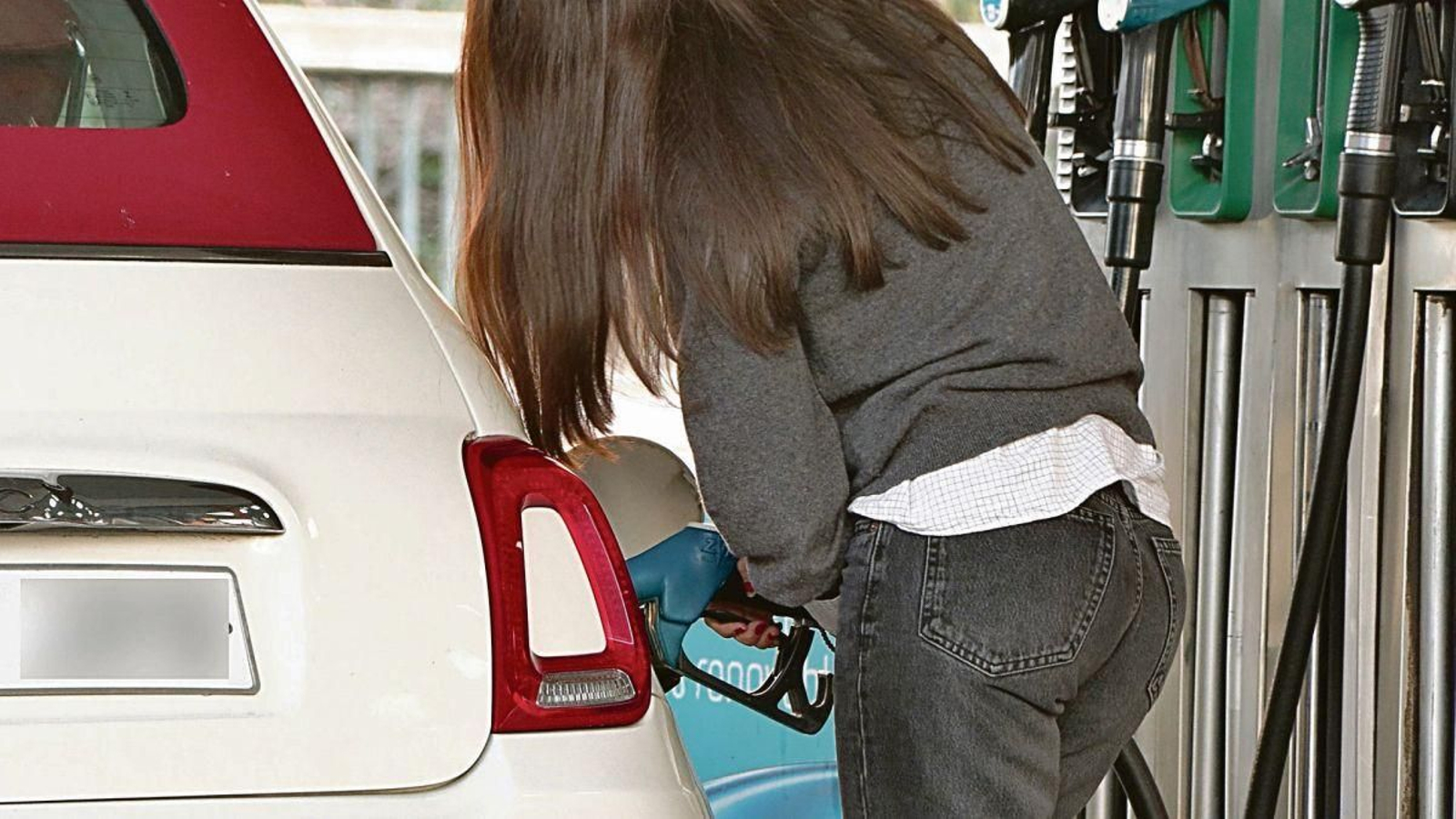 Una persona reposta en una gasolinera.