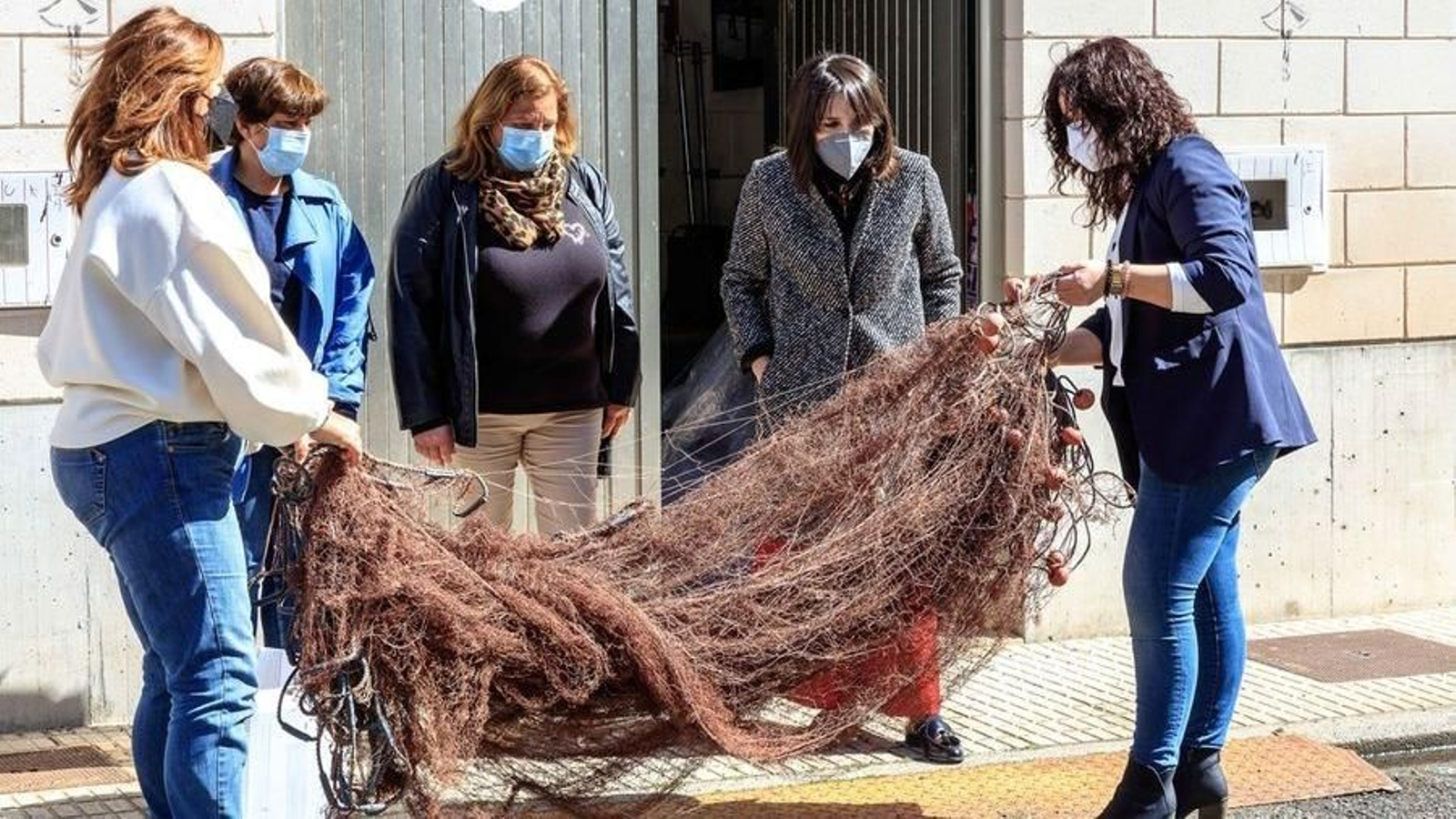 La conselleira de Emprego e Igualdade, María Jesús Lorenzana, observa el trabajo de las redeiras de Malpica.