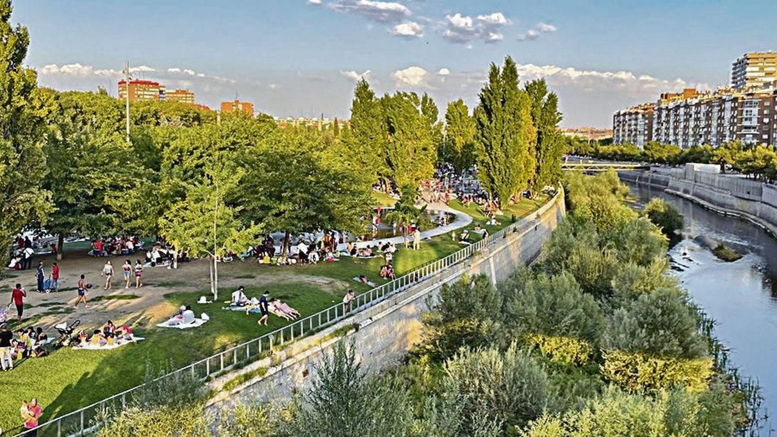 Vecios madrileños descansan en el entorno del Manzanares del parque Madrid Río.