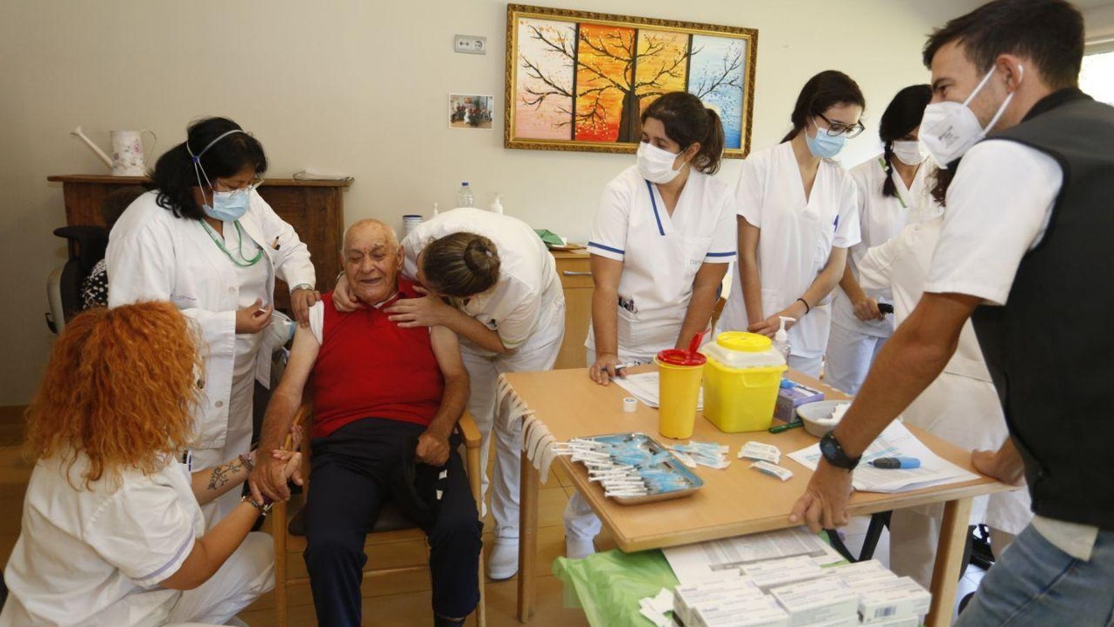 Un grupo de sanitarios, con un anciano que recibe la cuarta dosis, en una residencia de Vigo este lunes. // J.V. Landín